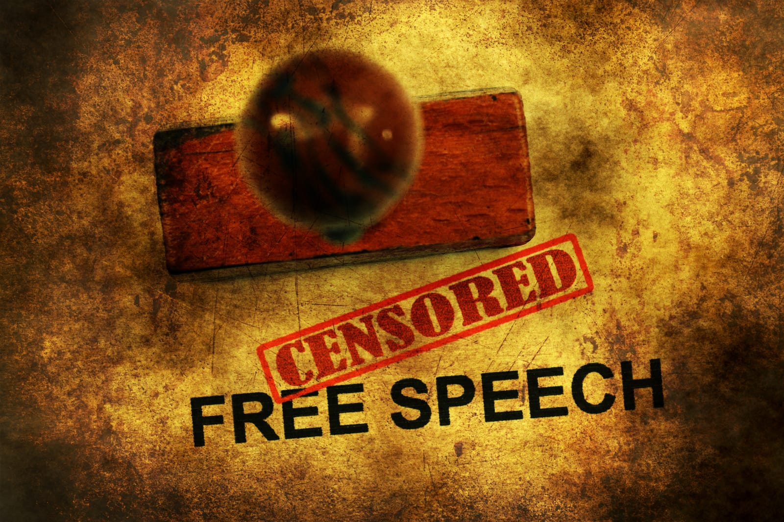 The words 'FREE SPEECH' are stamped on a textured surface, with a red 'CENSORED' stamp placed over them, symbolizing the conflict between free expression and censorship.