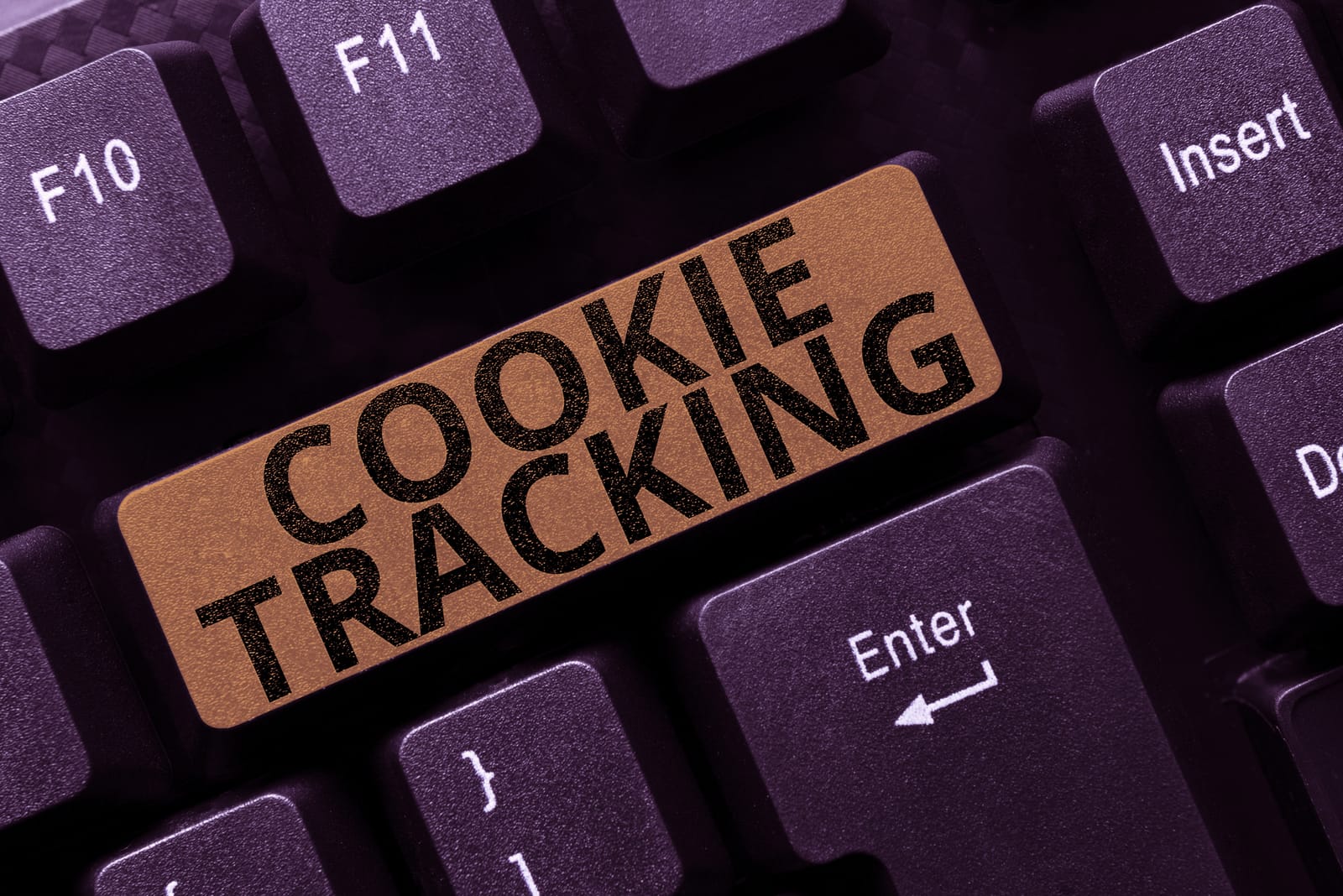 A close-up of a computer keyboard where a key has been replaced with a bronze-colored one that says 'COOKIE TRACKING', symbolizing the role of cookies in online privacy.